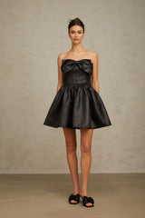 A short black metallic mini dress with a bow detail featuring a fitted silhouette and shimmering fabric
