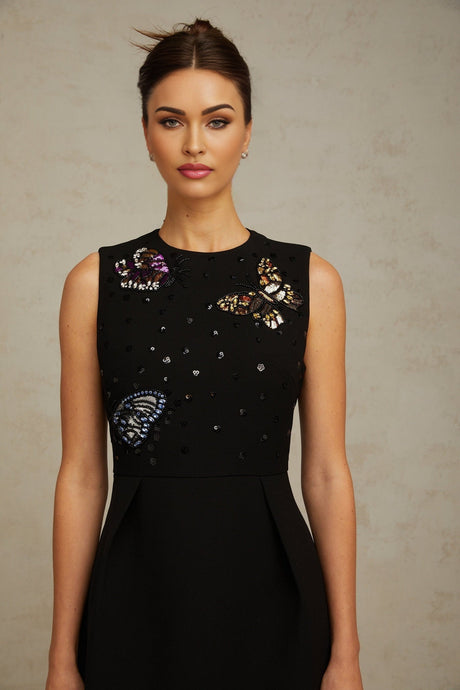 A short black mini dress adorned with sequins featuring a butterfly design with a fitted silhouette and shimmering details