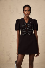A short black mini dress with a decorative bowknot detail