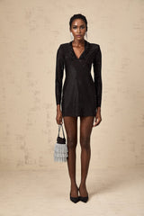 A short black mini dress with a plunging V neckline and allover silver stud embellishments