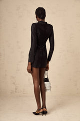 A short black mini dress with a plunging Vneckline adorned with silver studs and embellishments featuring long sleeves and a fitted silhouette