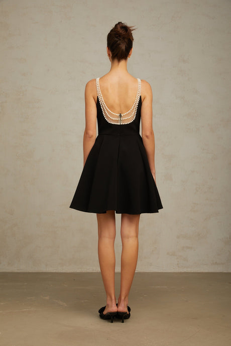 A short black mini dress with faux pearl embellishments named Danae