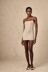 A short black mini dress with metallic stud embellishments adorning the fabric creating a textured and eyecatching design