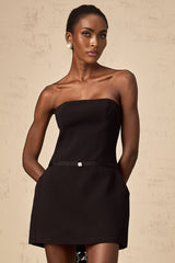 A short black mini dress with puff sleeves and a decorative bowknot detail
