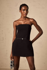 A short black mini dress with puffed sleeves and a decorative bowknot detail
