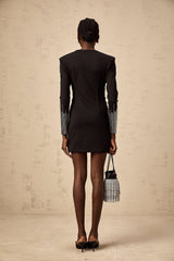 A short black mini dress with rhinestone embellishments and gathered fabric details worn by a model against a plain background