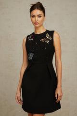 A short black mini dress with sequin embellishments in a butterfly pattern