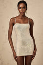 A short black mini dress with silver stud embellishments covering the fabric creating a shimmering effect The dress has a sleeveless design and a form fitting silhouette