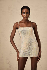 A short black mini dress with silver stud embellishments covering the fabric featuring a sleeveless design and a fitted silhouette