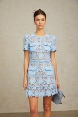 A short blue dress with floral lace applique and ruffled details