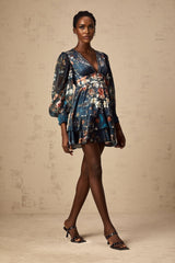 A short blue mini dress with a graphic print pattern and embellishments worn by a model named Candice