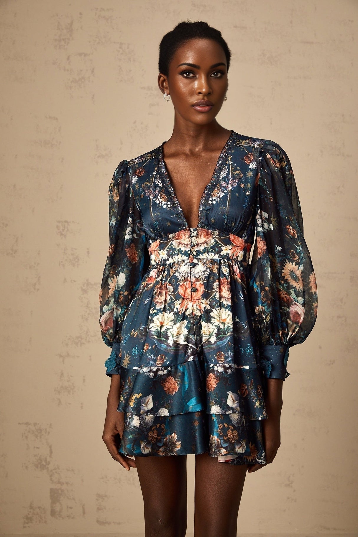 A short blue mini dress with a graphic print pattern and embellishments worn by a model named Candice