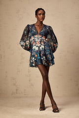 A short blue mini dress with a graphic print pattern and embellishments worn by a model named Candice