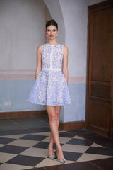 A short blue mini dress with crochet lace detailing and puffed sleeves on a white background