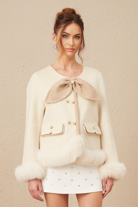 A short coat in two contrasting colors featuring a prominent bowknot detail named Theophila