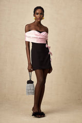 A short colorblocked mini dress with a bow embellishment featuring contrasting colors called Doria
