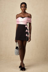 A short colorblocked mini dress with a bow embellishment in contrasting colors featuring a fitted silhouette and feminine design details