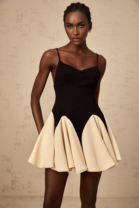 A short dress with a colorblocked design and godet pleated skirt featuring contrasting colors and a mini length