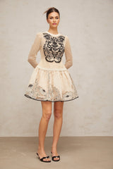 A short dress with a floral pattern featuring contrasting colors and floral applique details on a jacquard fabric background
