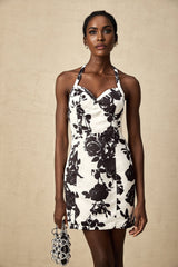 A short floral print halterneck mini dress with a vibrant pattern and feminine silhouette