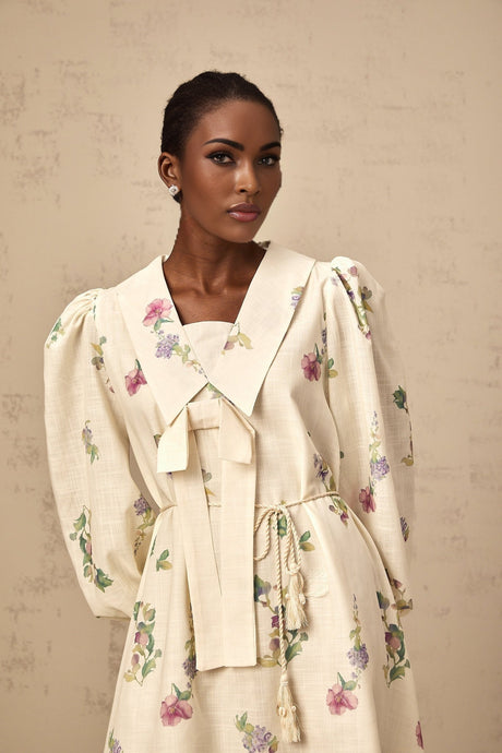 A short floral print mini dress in neutral colors featuring a bow detail