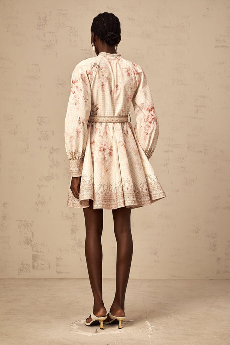 A short floral print mini dress with a belt cinching the waist featuring a vibrant pattern and feminine silhouette
