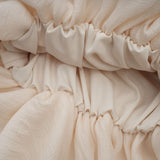 A short floral tiered mini dress in neutral tones with applique flower details