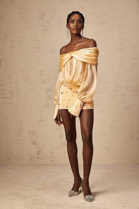 A short gold mini dress with crystal embellishments and panelled design featuring a sleeveless silhouette and sparkly details