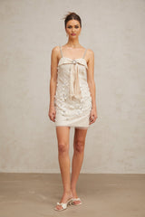 A short gold sequincovered mini dress with long sleeves and a high neckline shimmering under light