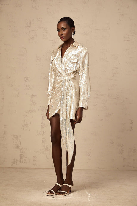 A short gold sequined mini dress with long sleeves and a wrapstyle design featuring a plunging neckline and cinched waist
