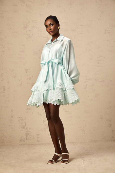 A short green dress with lace panels and a shirtstyle design featuring a collar and buttons