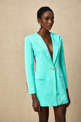 A short green mini dress with a blazerstyle top and cinched waist combining business and casual styles