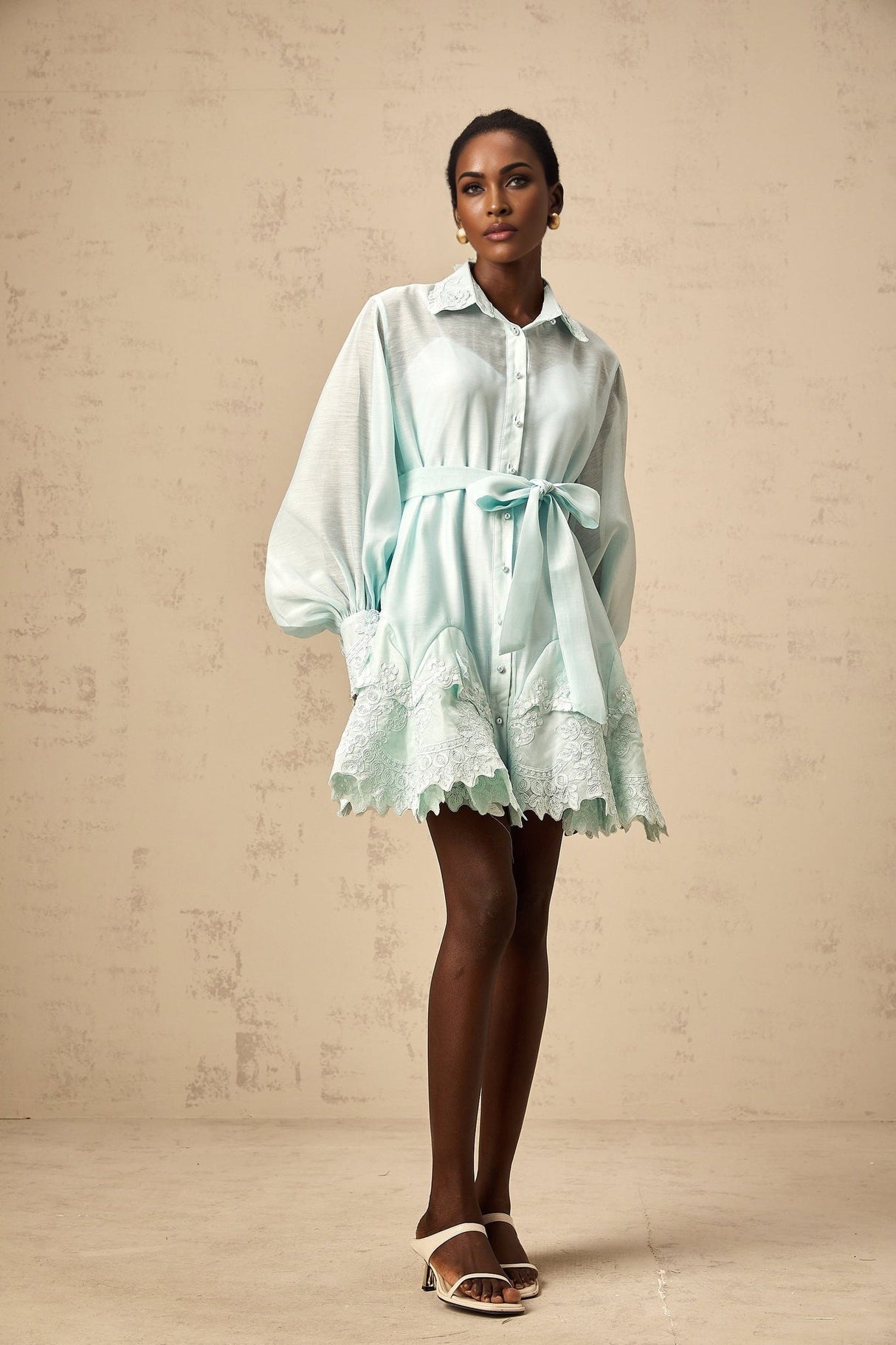 A short green mini dress with lace panel details and a shirt collar design