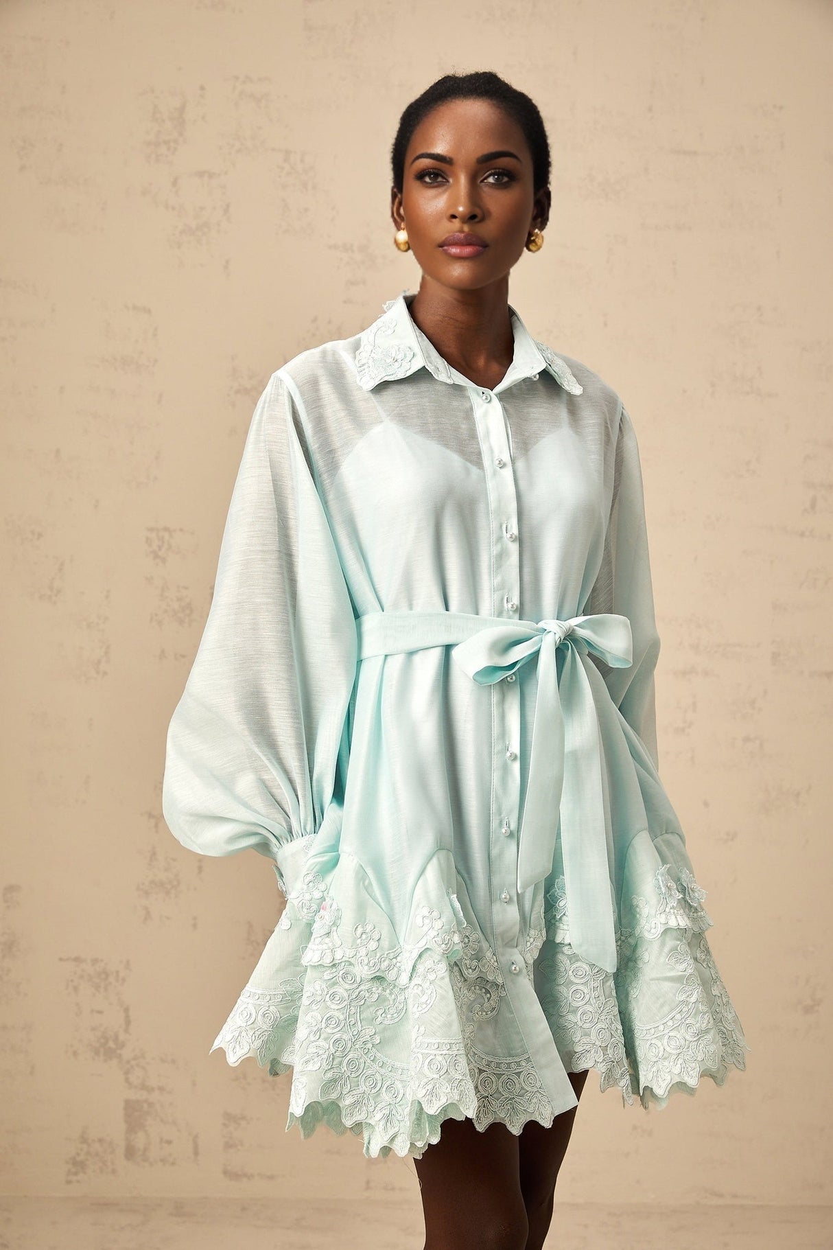 A short green mini dress with lace panel details and a shirt style collar