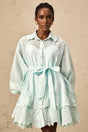 A short green mini dress with lace panel details and a shirtstyle design featuring a collar and buttons