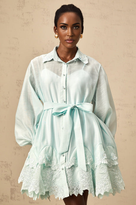 A short green mini dress with lace panel details and a shirtstyle design featuring a collar and buttons