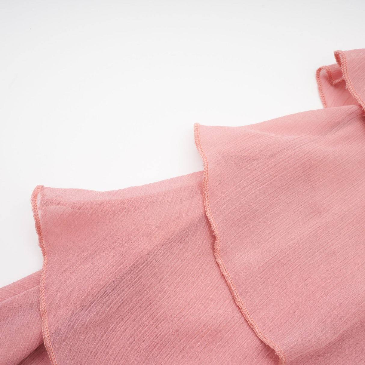 A short halterneck mini dress in briar pink color with tiered layers creating a flowy silhouette