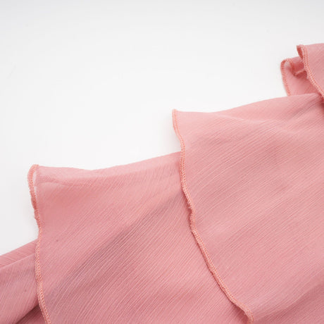 A short halterneck mini dress in briar pink color with tiered layers creating a flowy silhouette