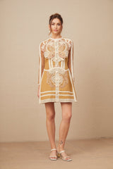 A short lace mini dress with cutout details and a peplum waist in a light color likely white or ivory