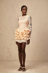 A short light colored dress with tiered layers and floral lace panels featuring a high neckline and long sleeves