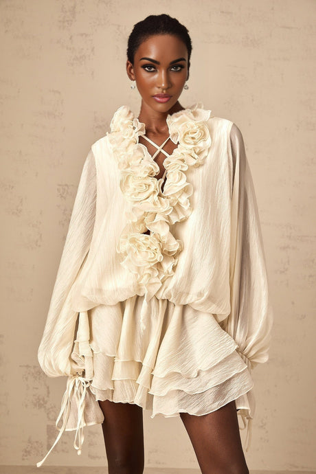A short light colored tiered mini dress with floral applique details called Zephyrine