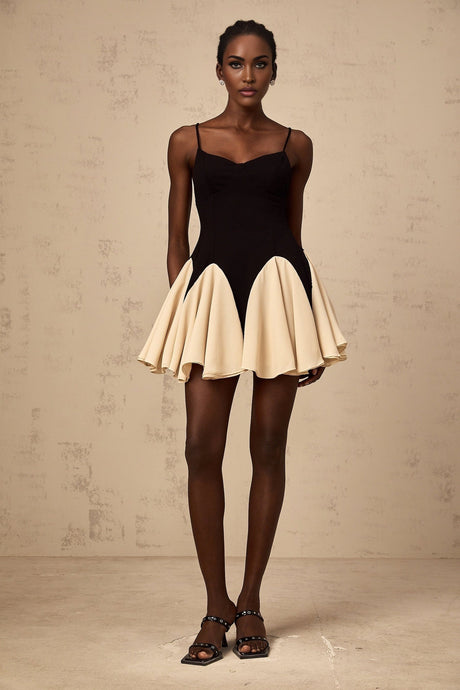 A short mini dress featuring color blocking and godet pleated design with the name Justine