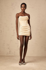 A short neutral colored mini dress with a sequined tulle overlay featuring a sleeveless design and a fitted silhouette