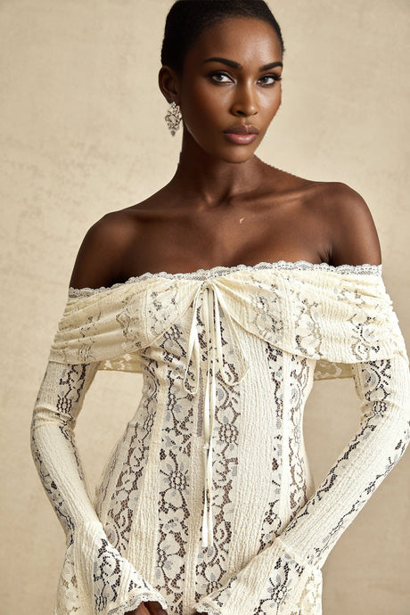 A short neutral colored mini dress with floral lace pattern and flared cuffs called Emeline