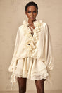 A short neutral colored mini dress with tiered layers and floral applique details named Zephyrine