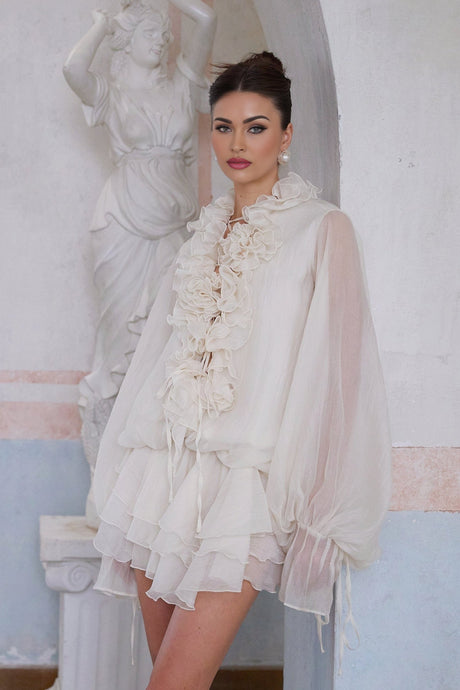 A short neutral colored tiered mini dress with floral applique details called Zephyrine