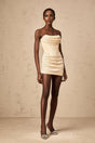 A short neutralcolored mini dress with sequin embellishments and a tulle overlay featuring a fitted silhouette and shimmering details