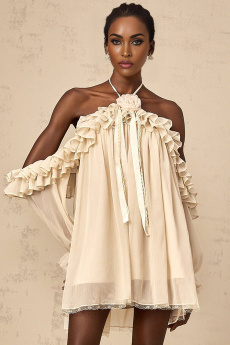 A short neutraltoned mini dress with ruffled details and floral appliques adorning the fabric