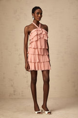 A short pink dress with a halter neckline and tiered skirt layers in a light briar rose color