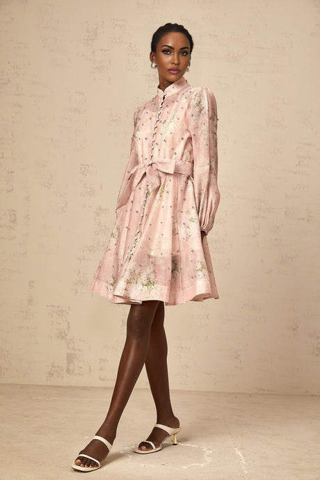 A short pink dress with floral print pattern and embellishments featuring a fitted silhouette and mini length